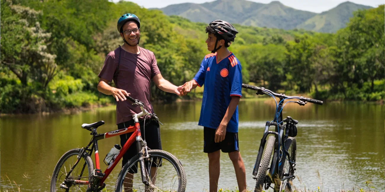 Personas disfrutando de un paseo en bicicleta cerca del lago en la venta de lotes campestres cerca de Bogotá